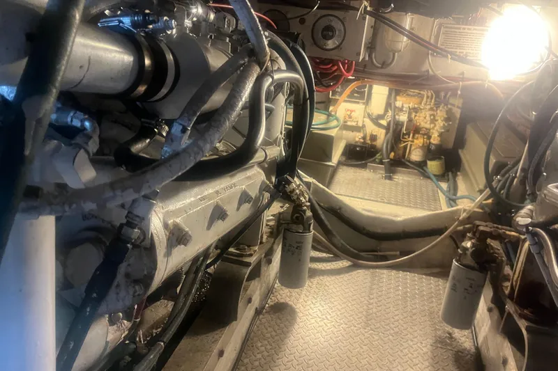 Slide: The Image of Engine room of a 1993 Bertram 37 Convertible boat, showcasing mechanical components and wiring. - 48