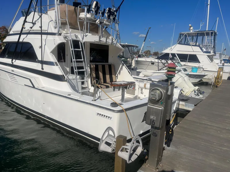 Slide: The Image of 1993 Bertram 37 Convertible yacht docked at marina under clear blue sky. - 6