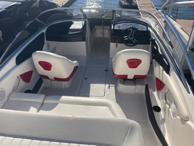 Slide: The Image of 2008 Regal 1900 Bowrider interior with white and red seating, docked by the water. - 6