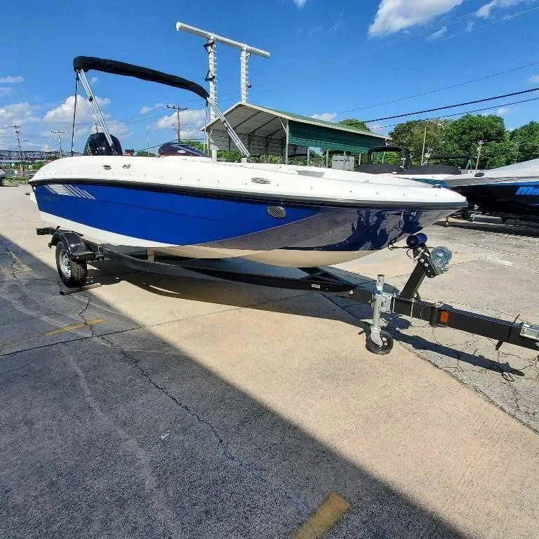 Slide: The Image of 2025 Bayliner E18 boat on trailer under clear blue sky. - 10