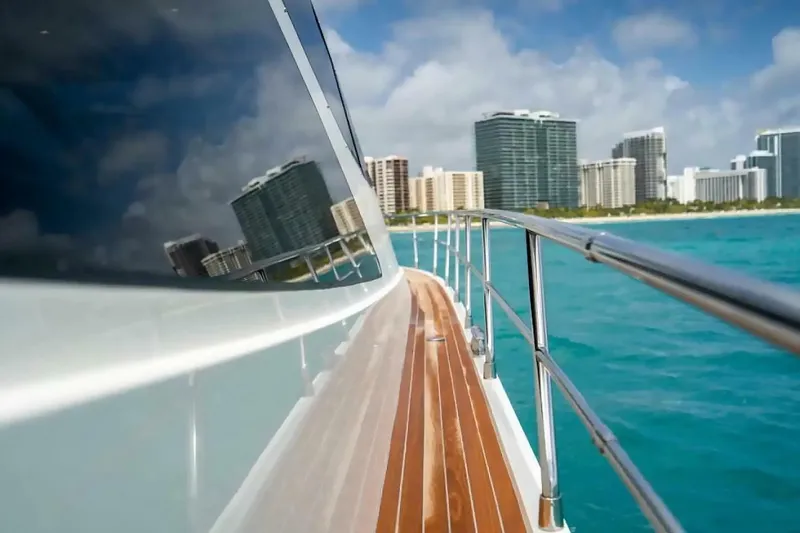Slide: The Image of Uniesse 68 Sport Yacht 2009 cruising near city skyline, turquoise water. - 10