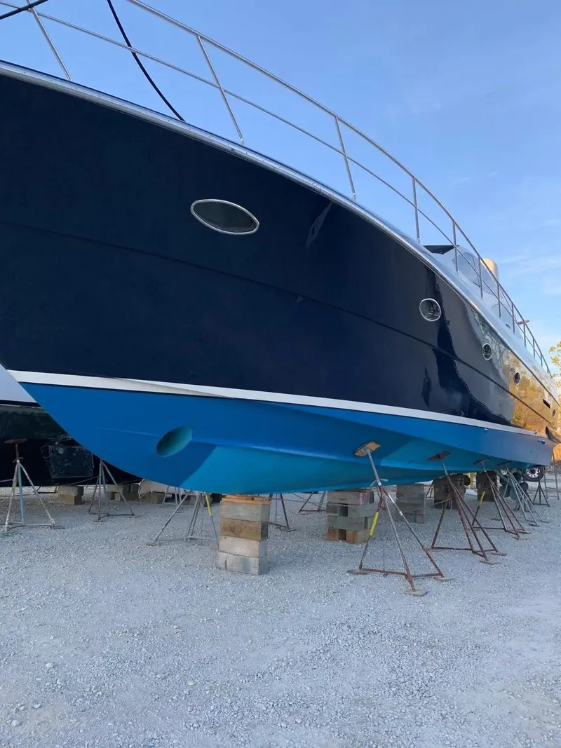 Slide: The Image of 2009 Uniesse 68 Sport Yacht on dry dock, blue hull, side view. - 39