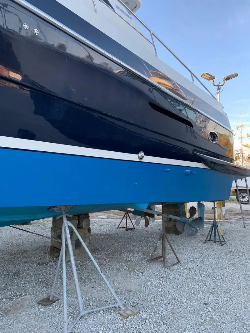 Slide: The Image of 2009 Uniesse 68 Sport Yacht on stands, blue hull, outdoor setting. - 40