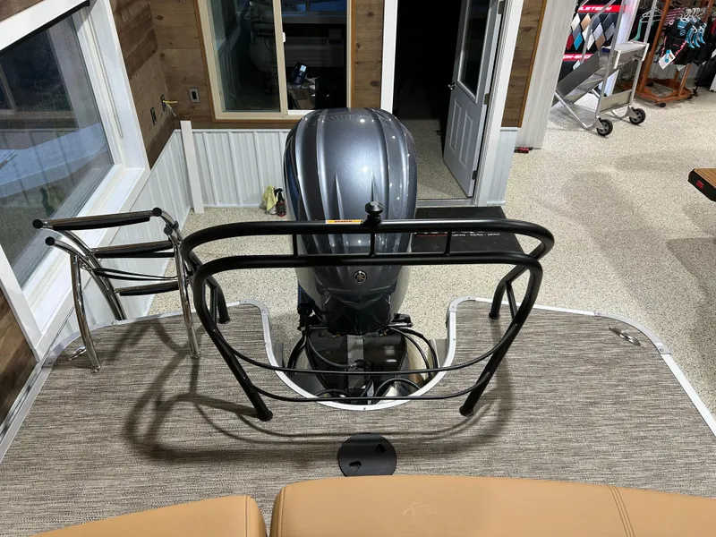 Slide: The Image of 2025 Godfrey Aqua Patio 235 ULC boat interior with motor and seating area. - 17