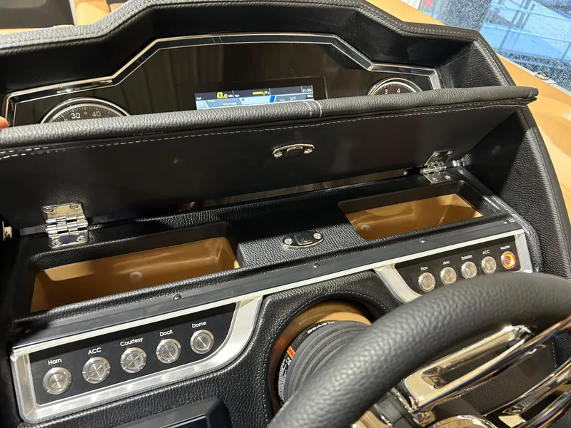 Slide: The Image of Dashboard of 2025 Godfrey Aqua Patio 235 ULC with control buttons and storage compartment. - 9