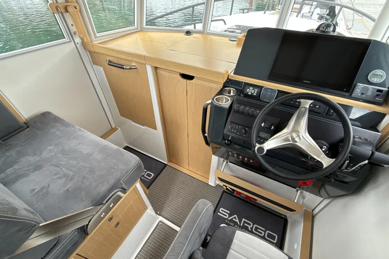 Slide: The Image of 2025 Sargo 31OB boat interior with modern helm, steering wheel, and navigation equipment. - 12