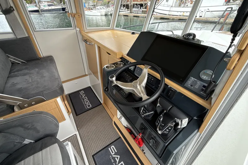 Slide: The Image of Interior of 2025 Sargo 31OB boat, featuring modern helm with steering wheel and controls. - 15