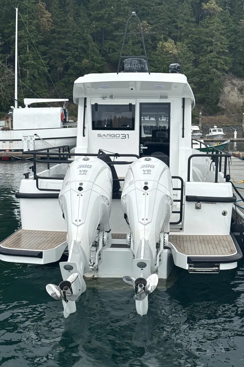 Slide: The Image of 2025 Sargo 31OB boat with dual outboard engines docked in a scenic marina. - 18