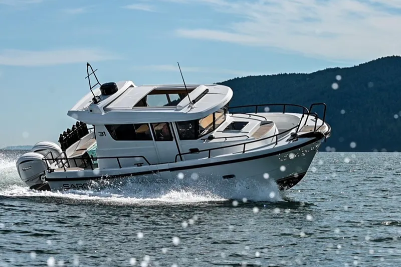 Slide: The Image of 2025 Sargo 31OB boat cruising on open water with scenic mountain backdrop. - 2