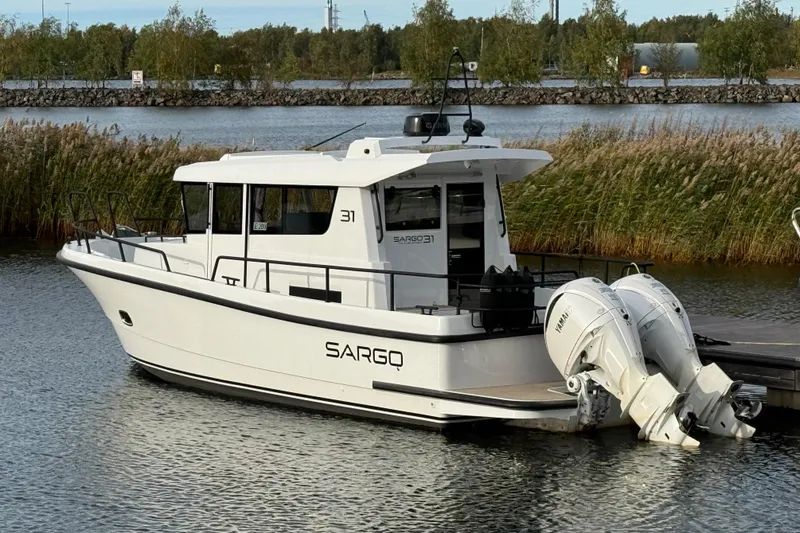 Slide: The Image of 2025 Sargo 31OB boat with dual outboard engines on a calm lake. - 24