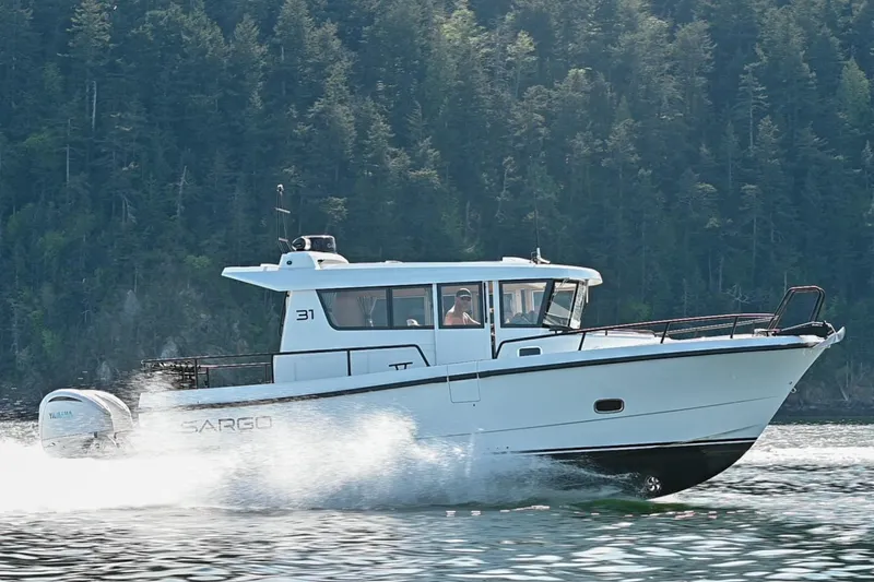 Slide: The Image of 2025 Sargo 31OB boat cruising on water with forested background. - 3