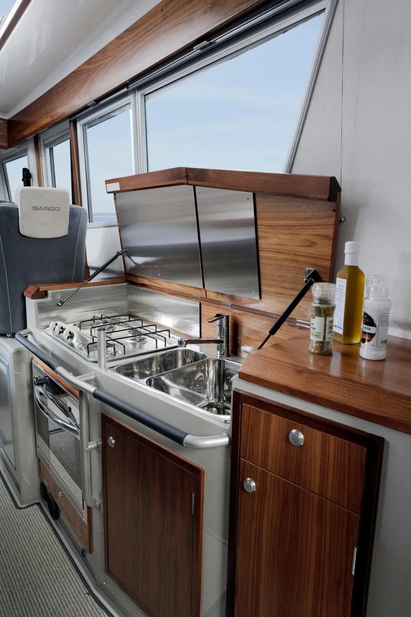 Slide: The Image of Modern kitchen interior of 2025 Sargo 31OB boat with wood accents and stainless steel appliances. - 30