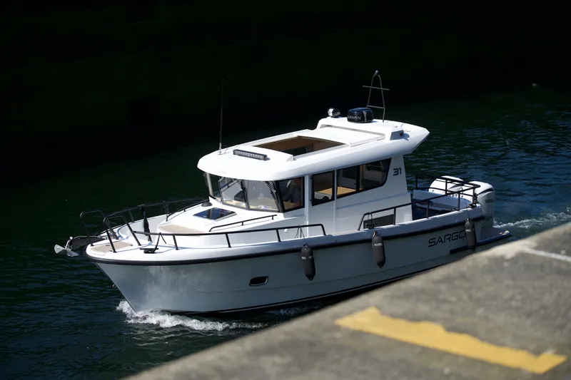 Slide: The Image of 2025 Sargo 31OB boat cruising on water, side view. - 8