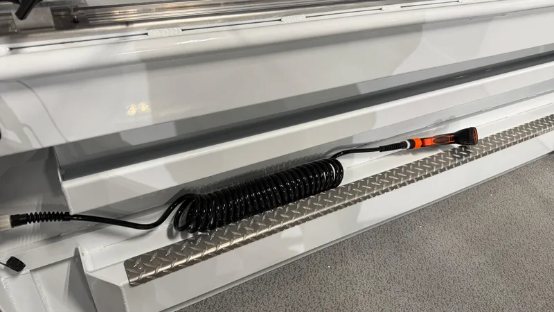 Slide: The Image of 2025 Hewescraft 240 Ocean Pro ET HT boat detail with coiled cable on metal surface. - 13