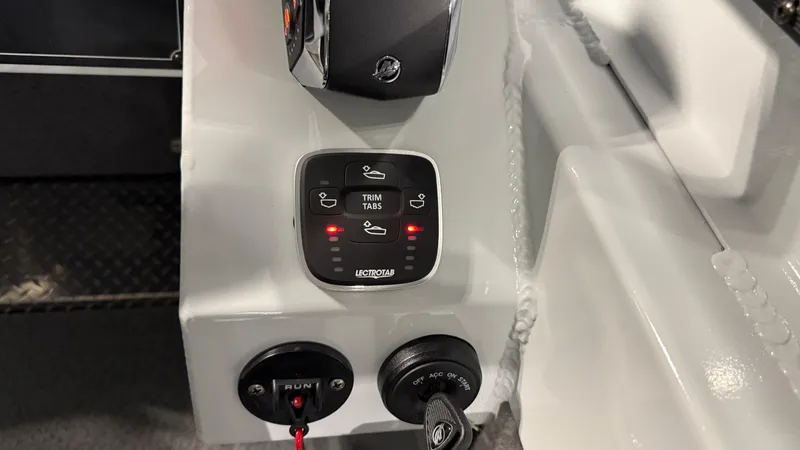 Slide: The Image of Control panel of 2025 Hewescraft 240 Ocean Pro ET HT boat with trim tab buttons. - 27
