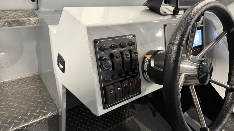 Slide: The Image of 2025 Hewescraft 240 Ocean Pro ET HT dashboard with steering wheel and control panel. - 29