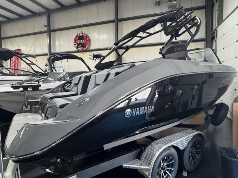 Slide: The Image of 2025 Yamaha Boats 222XD in showroom, sleek black design on trailer. - 7