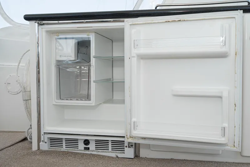 Slide: The Image of Open refrigerator on 2008 Navigator 62 Pilothouse yacht, showing empty shelves and ice maker. - 18