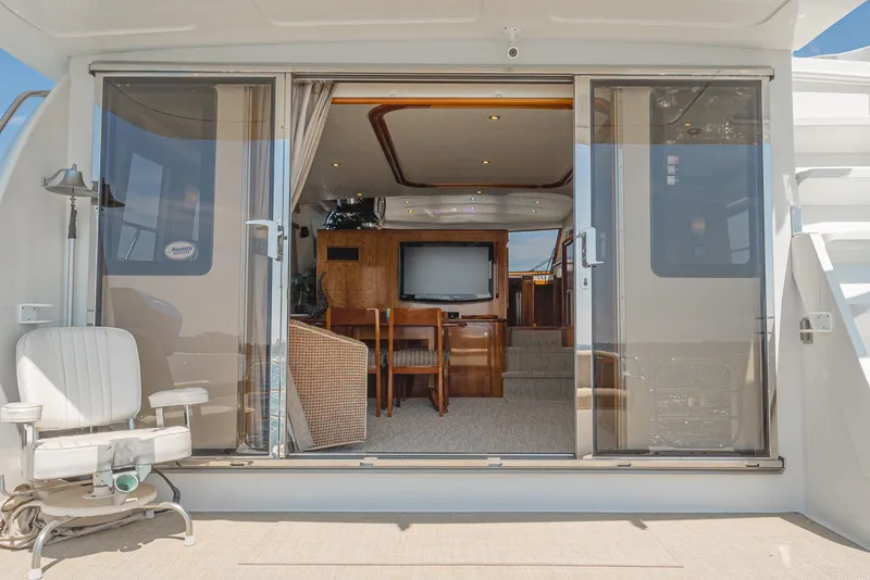 Slide: The Image of 2008 Navigator 62 Pilothouse yacht interior with sliding glass doors and seating area. - 23