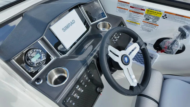 Slide: The Image of 2025 Bayliner VR6 boat dashboard with steering wheel and Simrad display. - 19