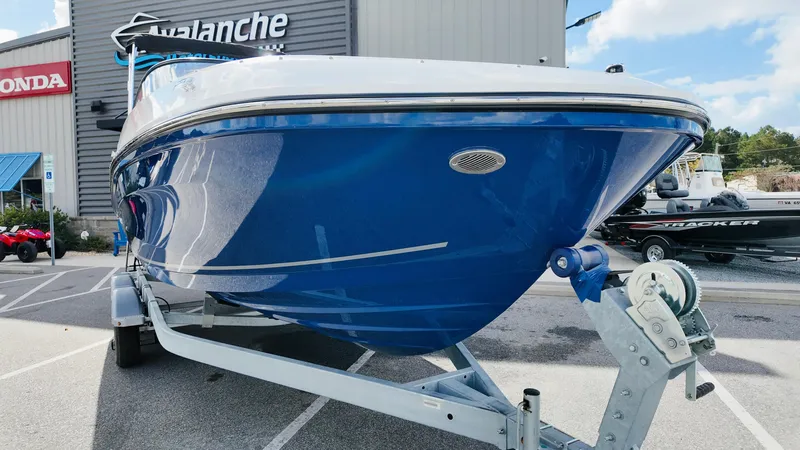 Slide: The Image of 2025 Bayliner VR6 boat on trailer at dealership, blue hull, parked outdoors. - 3