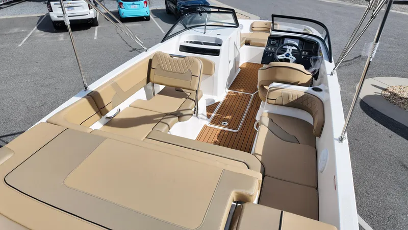 Slide: The Image of 2025 Bayliner VR6 boat interior with beige seating and modern dashboard. - 10