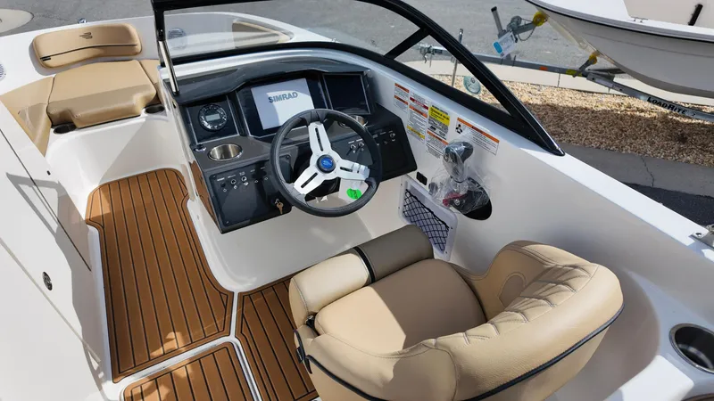 Slide: The Image of 2025 Bayliner VR6 boat interior with modern dashboard and beige seating. - 14