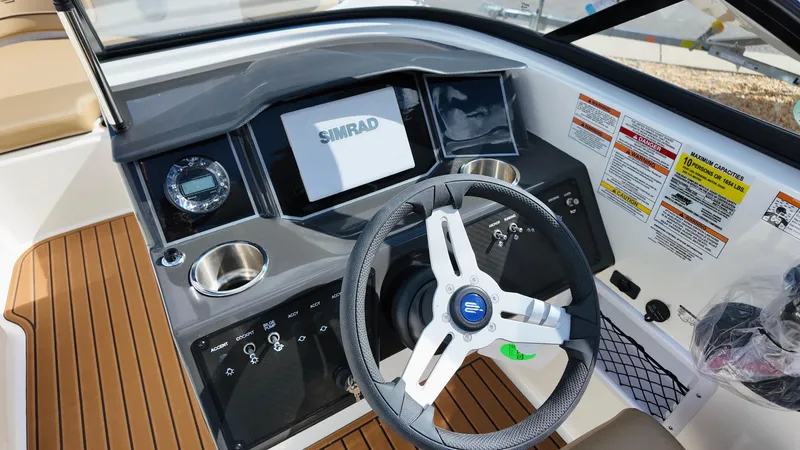 Slide: The Image of 2025 Bayliner VR6 boat dashboard with Simrad display and modern steering wheel. - 15