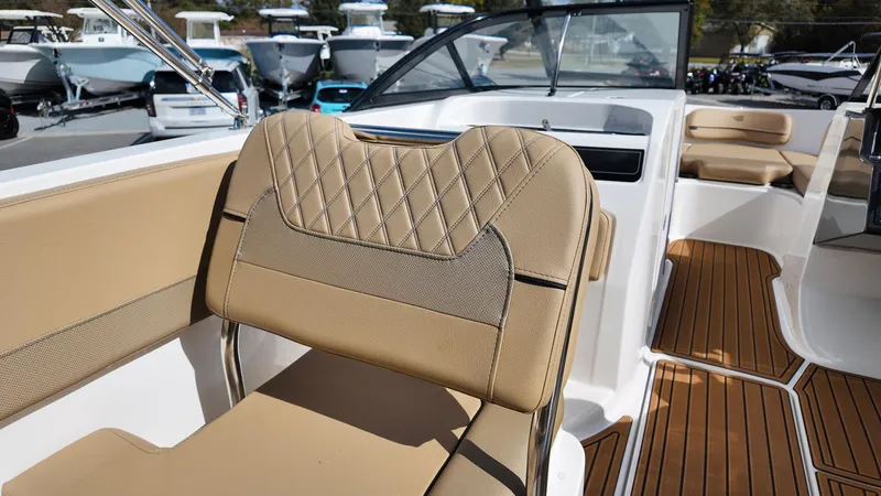 Slide: The Image of 2025 Bayliner VR6 boat interior with tan seating and wood-style flooring. - 18