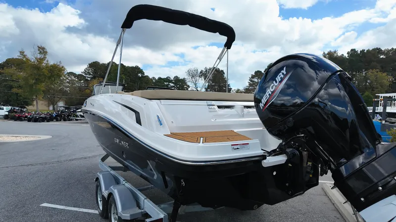 Slide: The Image of 2025 Bayliner VR6 boat on trailer with Mercury outboard motor, parked outdoors. - 6