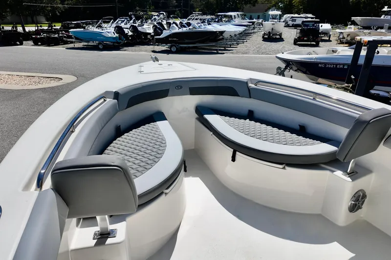 Slide: The Image of 2025 Defiance 240 Catalina boat interior with cushioned seating in a marina setting. - 11
