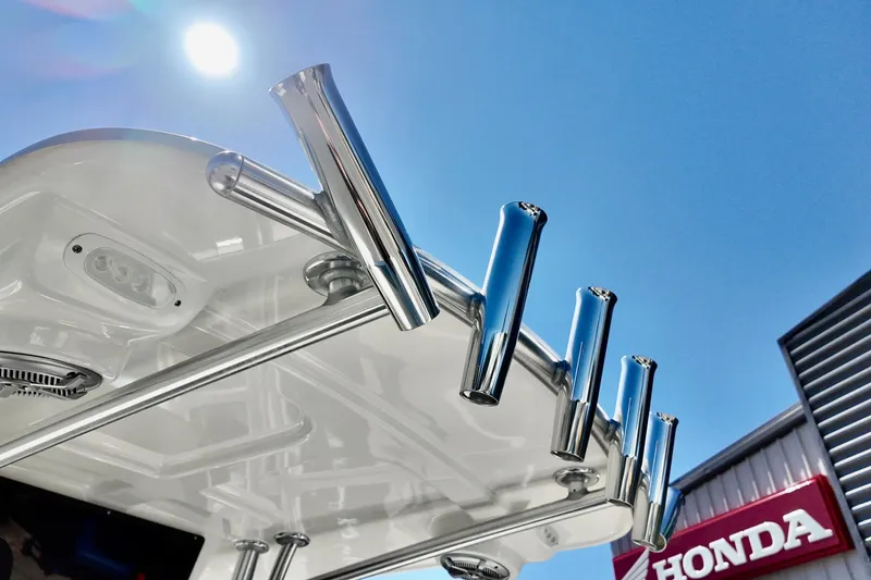 Slide: The Image of 2025 Defiance 240 Catalina boat with rod holders under a bright blue sky. - 4