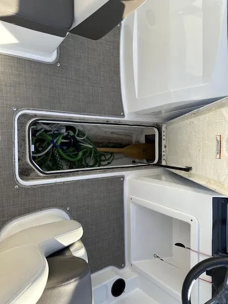 Slide: The Image of 2018 Bayliner VR4 boat interior storage compartment with ropes and paddle. - 8