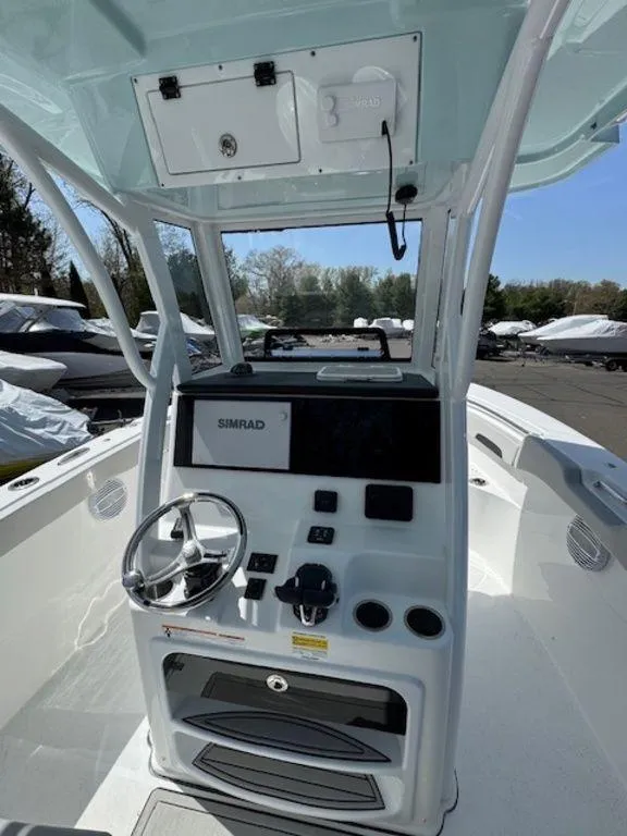 Slide: The Image of 2025 Sea Pro 262 DLX boat console with steering wheel and Simrad display. - 10