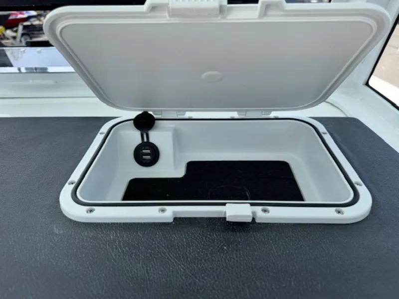 Slide: The Image of Open storage compartment on 2025 Sea Pro 262 DLX boat, featuring a USB port. - 14