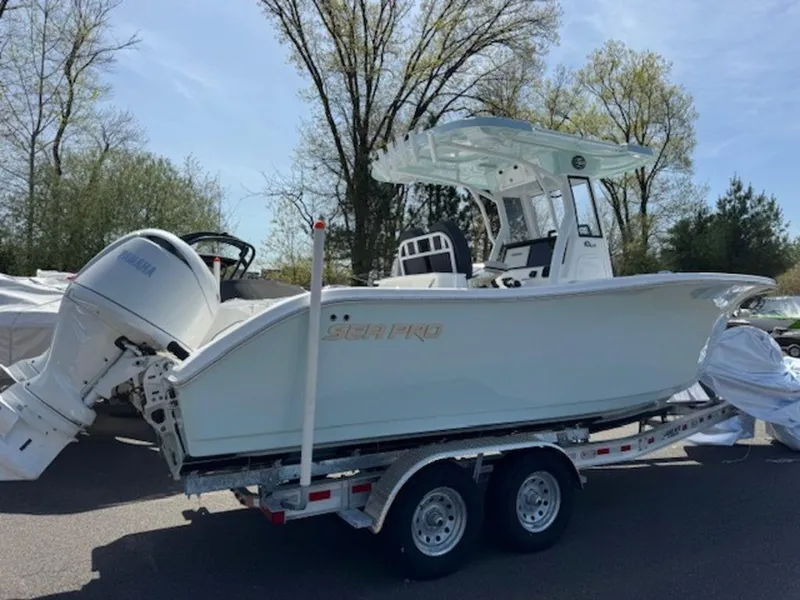 Slide: The Image of 2025 Sea Pro 262 DLX boat on trailer, parked outdoors. - 3