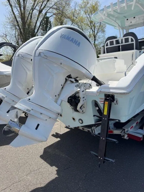Slide: The Image of 2025 Sea Pro 262 DLX boat with dual Yamaha outboard engines, parked outdoors. - 9