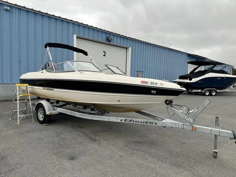 Slide: The Image of 2015 Stingray 191RX boat on trailer, parked outside blue warehouse. - 7