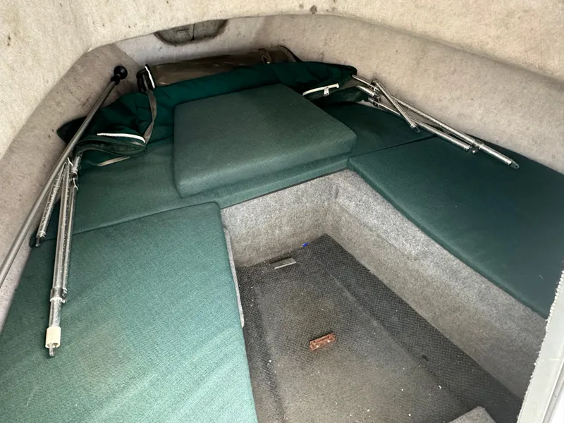 Slide: The Image of 2006 Trophy 1802 WA cabin interior with green cushions and metal poles. - 14