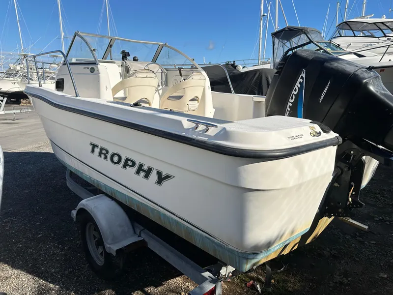 Slide: The Image of 2006 Trophy 1802 WA boat on trailer with outboard motor, docked in marina. - 4