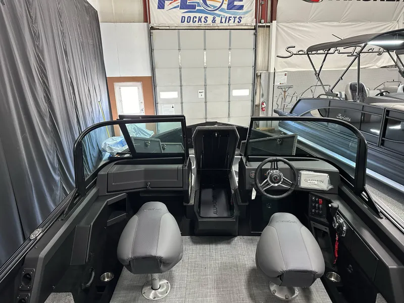 Slide: The Image of 2025 Alumacraft Competitor 205X Sport interior with dual seats and steering console in showroom. - 10