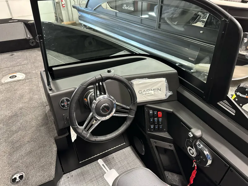 Slide: The Image of 2025 Alumacraft Competitor 205X Sport boat interior with steering wheel and Garmin navigation system. - 15