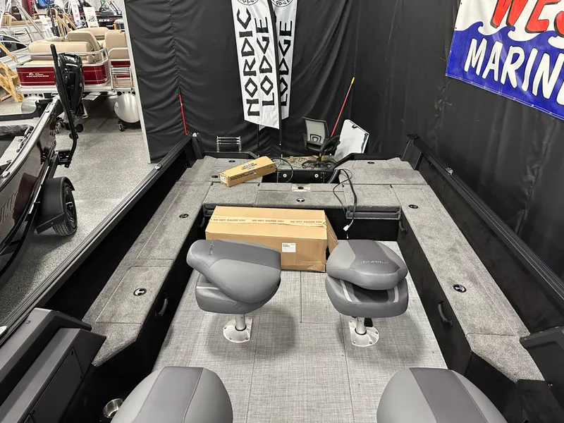Slide: The Image of 2025 Alumacraft Competitor 205X Sport boat interior with gray seating and storage boxes. - 18