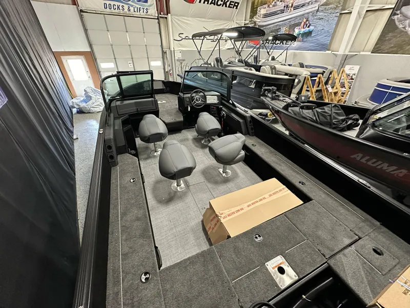Slide: The Image of 2025 Alumacraft Competitor 205X Sport boat interior with seating and control panel in showroom. - 20