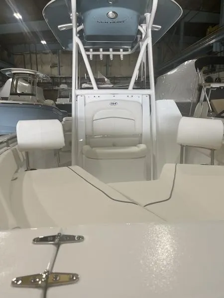 Slide: The Image of 2024 Sea Hunt Ultra 229 boat interior with seating and console in a showroom. - 10