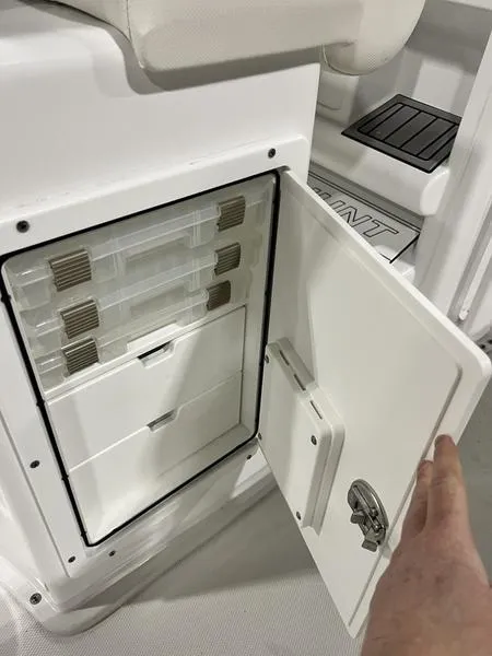 Slide: The Image of 2024 Sea Hunt Ultra 229 boat storage compartment with open door and organized trays. - 8