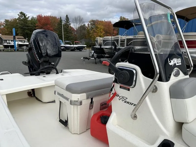 Slide: The Image of 2023 Mako SKIFF 17 CC boat with console and seating, parked outdoors. - 3