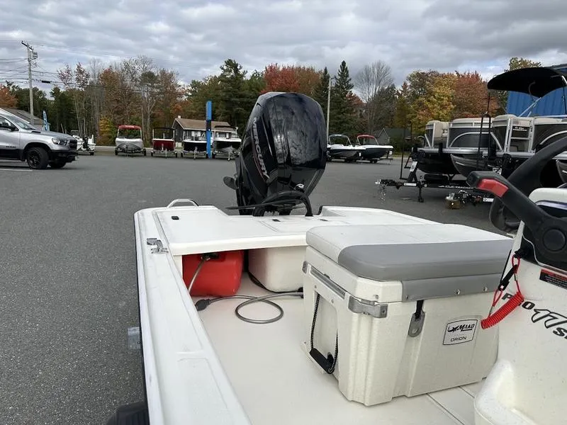 Slide: The Image of 2023 Mako SKIFF 17 CC boat with outboard motor in a parking lot. - 7