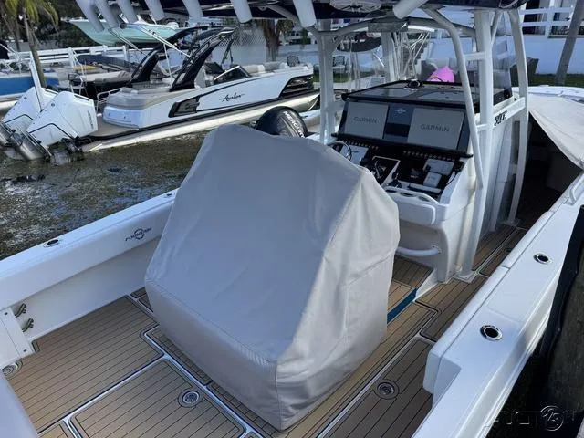 Slide: The Image of 2023 Fountain 34 CC boat with covered helm, docked near other boats. - 18