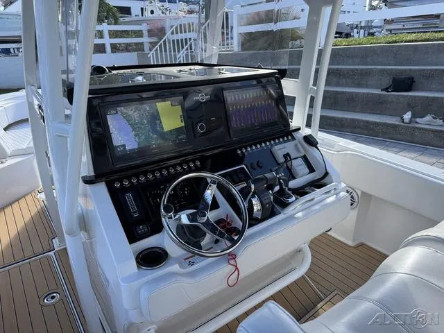 Slide: The Image of 2023 Fountain 34 CC boat cockpit with advanced navigation system and steering wheel. - 24